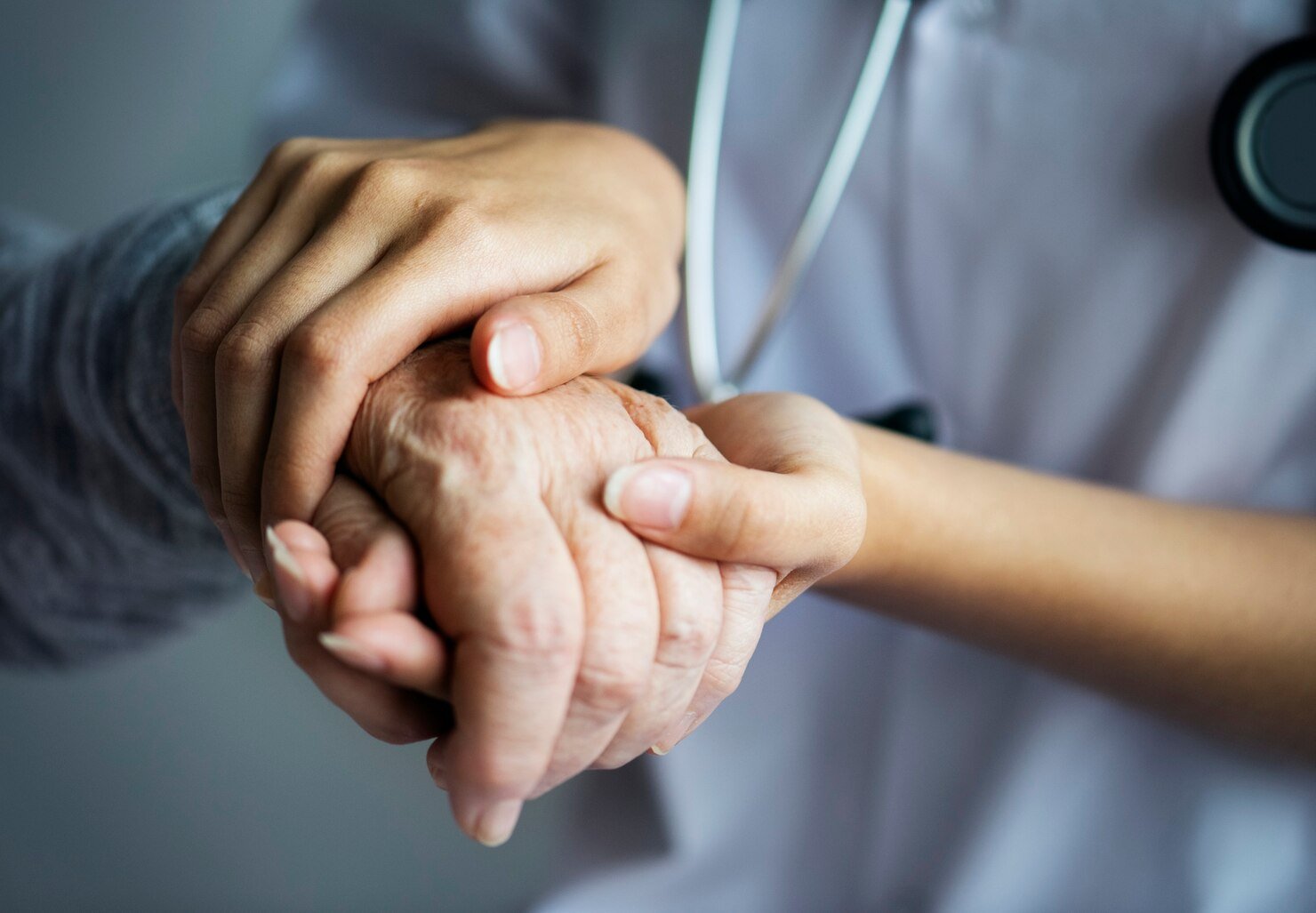 Doctor holding the hand of an elderly patient